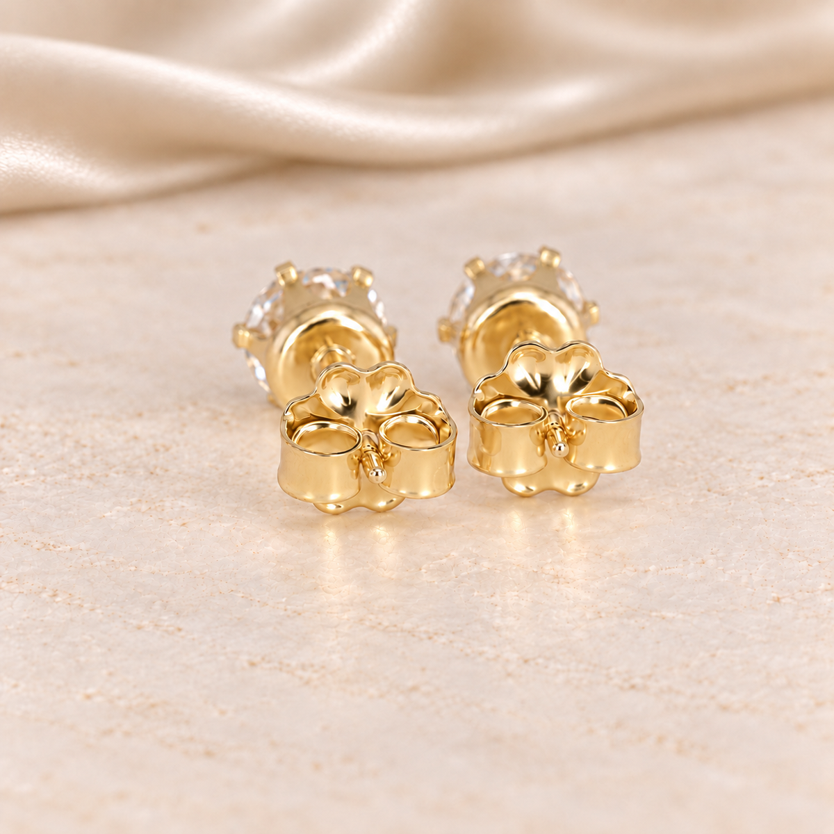 Back view of 1 CTW moissanite stud earrings showing 14/20 gold-filled posts, six-prong settings and butterfly backs.
