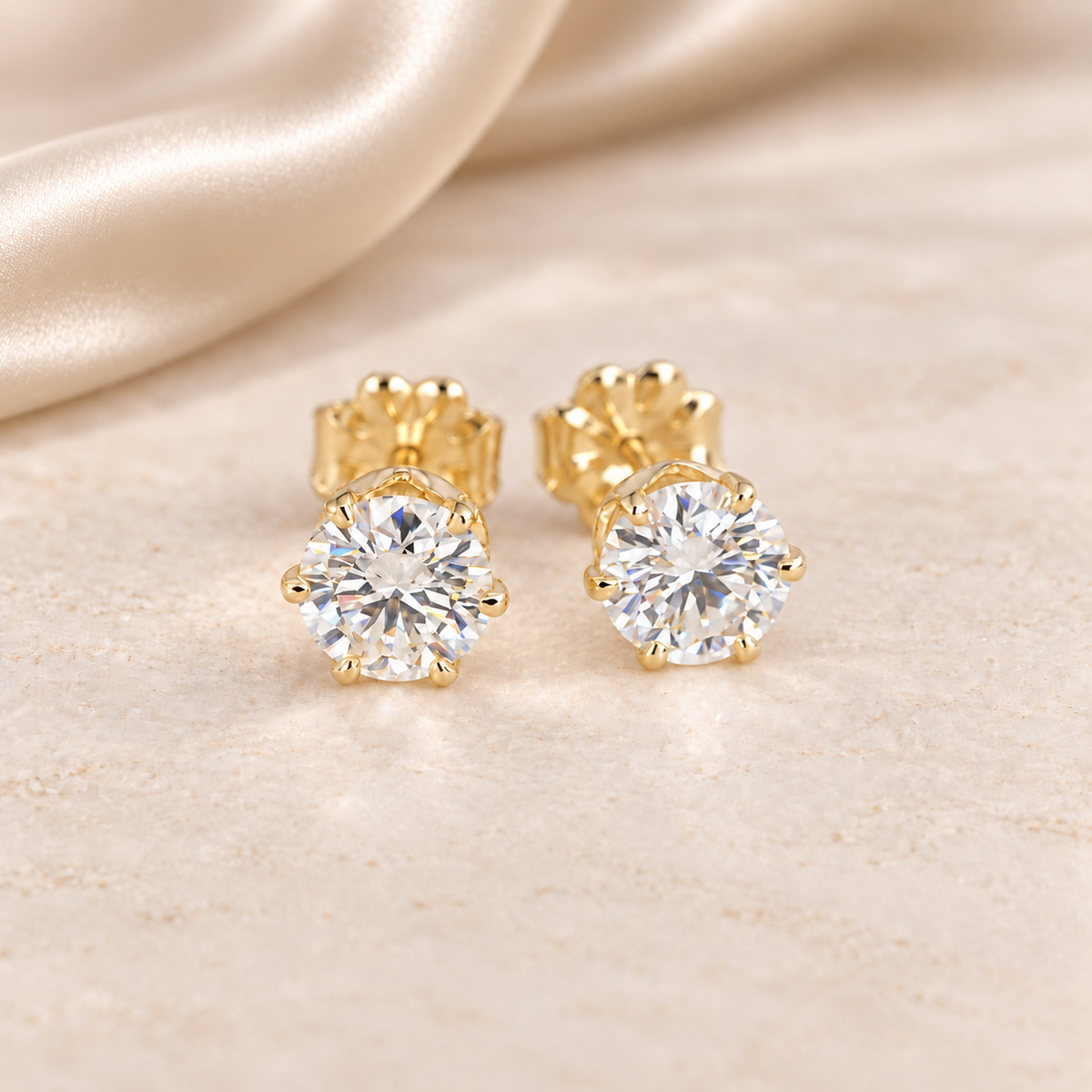Pair of 1 CTW round moissanite stud earrings in six-prong 14/20 gold-filled settings.