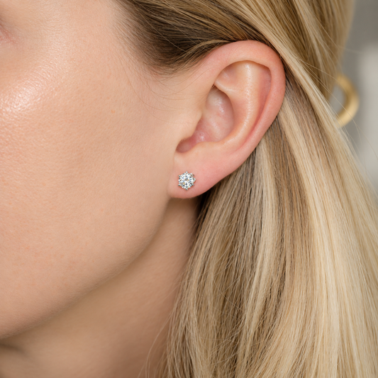 0.50 carat round moissanite stud earring worn on ear in a six-prong S925 sterling silver setting.